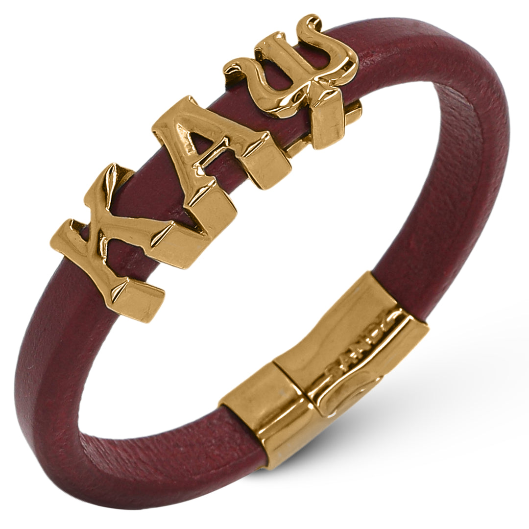 Bracelet with gold greek letters Kappa Alphs Psi on a red leather band against a white background