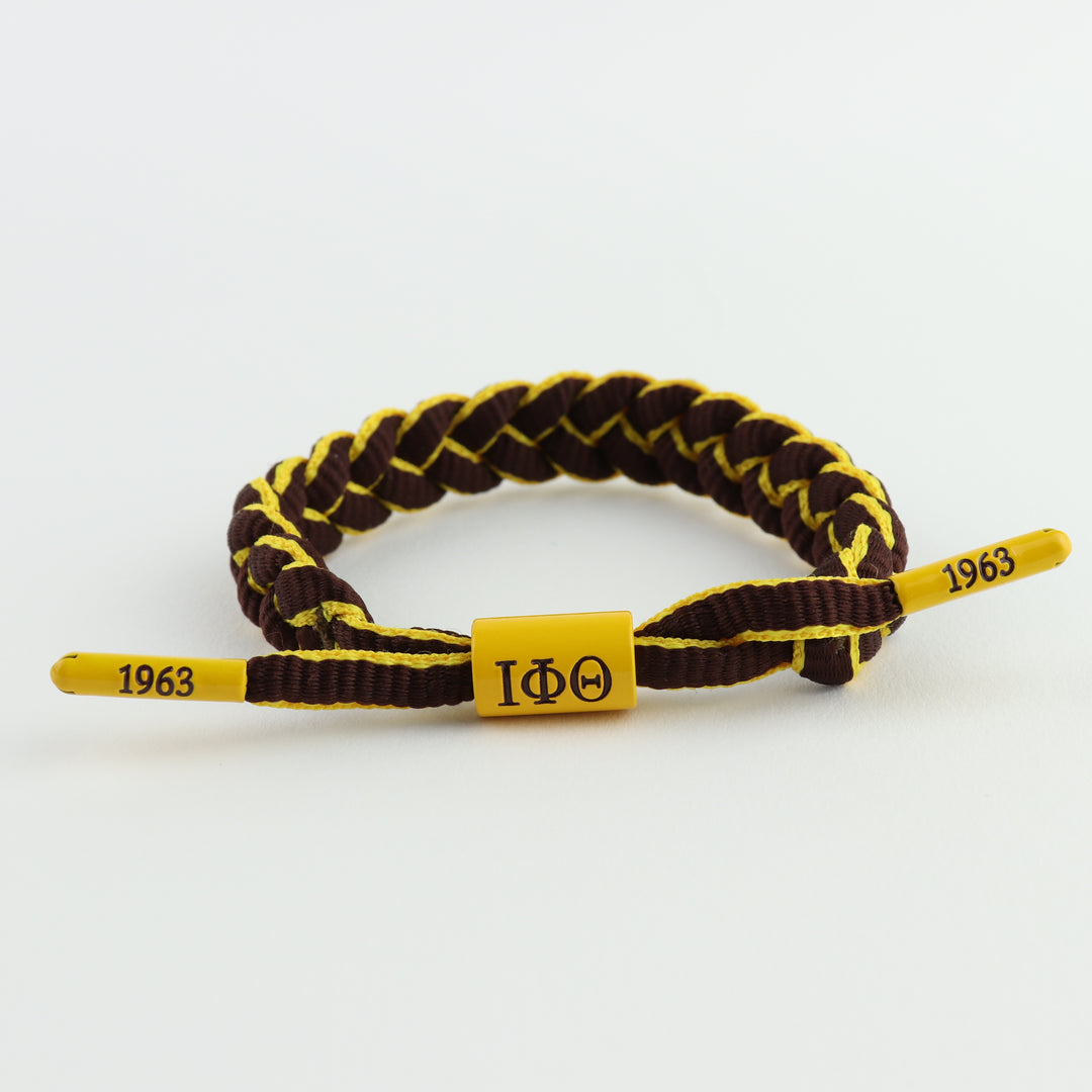 Iota Phi Theta bracelet featuring IΦΘ centerpiece and end caps embossed with 1963, braided paracord, adjustable, gift for Iotas, owtlaws  only at www.thesandz.com